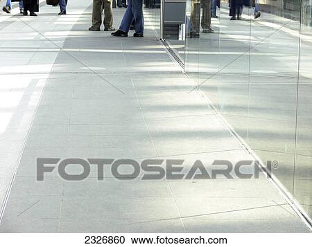Stock Image - Reflection of glass wall on tiled flooring . Fotosearch