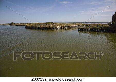 Stock Photo - River flowing through field, Valli Di Comacchio, Emilia-Romagna, Italy . Fotosearch