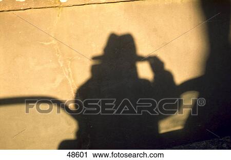 Stock Image - Shadow of a man on a wall . Fotosearch