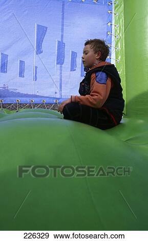 Side profile of boy meditating in bouncy castle, Hamburg, Germany View Large Photo Image Stock Photo - Side profile of boy meditating in bouncy castle, Hamburg, Germany . Fotosearch