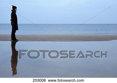 Side profile of woman standing on beach View Large Photo Image Stock Photo - Side profile of woman standing on beach . Fotosearch
