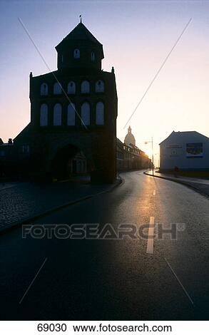Stock Image - Silhouette of building at roadside, Rostocker Tor, Ribnitz-Damgarten, Mecklenburg-Western Pomerania, Germany . Fotosearch