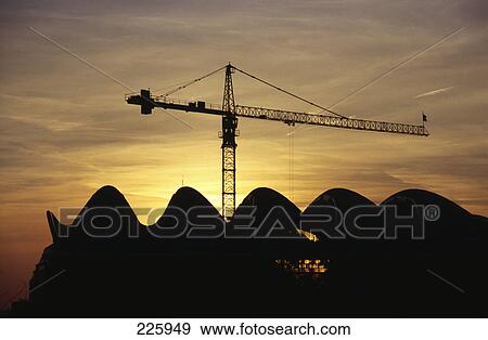 Stock Photo - Silhouette of exhibition hall and crane at dusk, Frankfurt, Hesse, Germany . Fotosearch