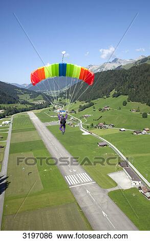 Skydiver in approach for landing, Saanen, Bern, Switzerland View Large Photo Image Stock Photograph - Skydiver in approach for landing, Saanen, Bern, Switzerland . Fotosearch