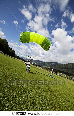 Skydiver landing on meadow, Reichenbach, Switzerland, slanted view View Large Photo Image Stock Image - Skydiver landing on meadow, Reichenbach, Switzerland, slanted view . Fotosearch