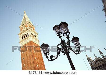 Stock Image - Street lamp in front of tower, Venice, Italy, view from below . Fotosearch