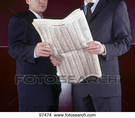 Picture - Two businessmen holding newspaper . Fotosearch