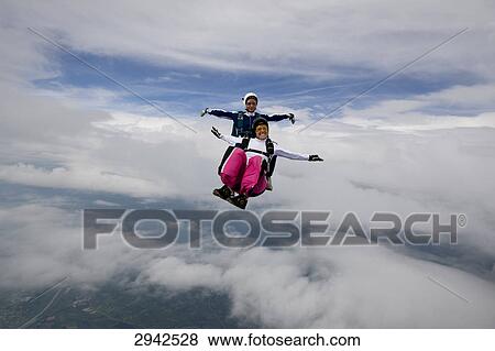 Stock Photo - two people doing parachute jumping, full shot . Fotosearch