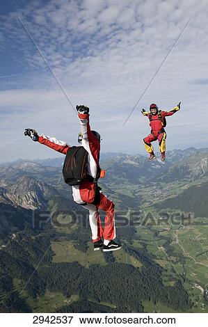 Stock Photo - two people doing parachute jumping, full shot . Fotosearch
