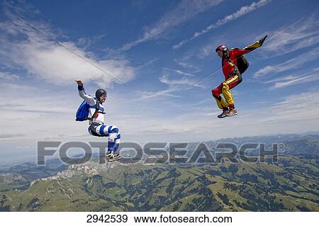 Stock Photo - two people doing parachute jumping, full shot . Fotosearch