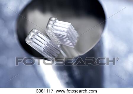 Stock Photo - Two toothbrushes in toothbrush cup, close-up . Fotosearch