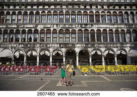 Two tourists near chairs arranged in town square, Piazza San Marco, St. Mark's Square, Veneto, Venice, Italy  View Large Photo Image Stock Photography - Two tourists near chairs arranged in town square, Piazza San Marco, St. Mark's Square, Veneto, Venice, Italy . Fotosearch