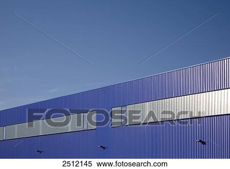 Stock Photography - Windows on blue wall of storehouse against blue sky . Fotosearch
