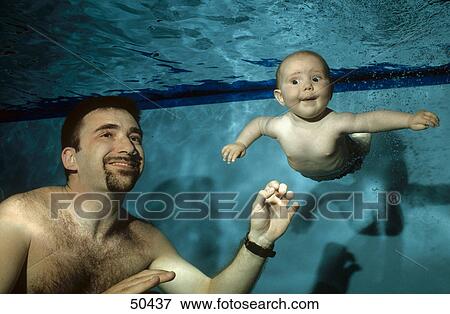 Baby swimming with father in indoor pool, underwater view  View Large Photo Image Stock Photo - Baby swimming with father in indoor pool, underwater view . Fotosearch