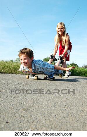 Boy and girl playing with skateboard View Large Photo Image Stock Photo - Boy and girl playing with skateboard . Fotosearch