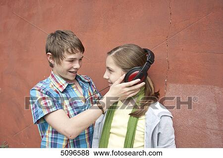 Boy and girl sharing headphones View Large Photo Image Stock Photo - Boy and girl sharing headphones . Fotosearch