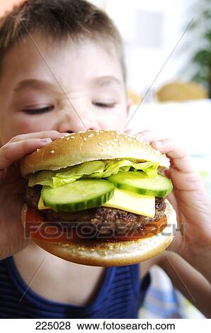 Boy eating burger View Large Photo Image Stock Photo - Boy eating burger . Fotosearch