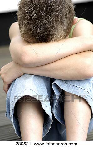 Boy hugging knees View Large Photo Image Stock Image - Boy hugging knees . Fotosearch
