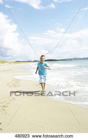 Stock Image - Boy running on beach . Fotosearch