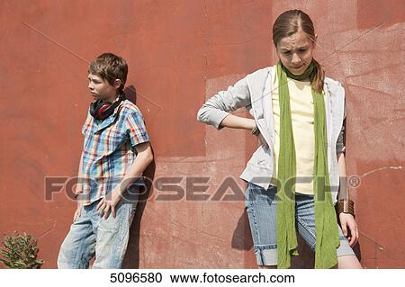 Boy with headphones and girl leaning at wall View Large Photo Image Stock Image - Boy with headphones and girl leaning at wall . Fotosearch