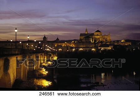 Stock Image - Bridge across river with mosque in background, Puente Romano, Guadalquivir River, Mezquita Catedral de Cordoba, Cordoba, Andalusia, Spain . Fotosearch