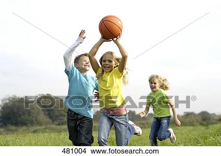 Picture - Brother and sisters playing basketball in field . Fotosearch