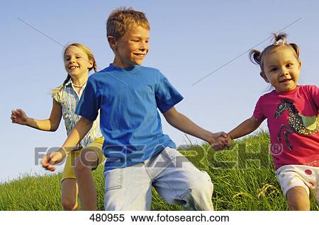 Brother and sisters running in field View Large Photo Image Stock Photography - Brother and sisters running in field . Fotosearch