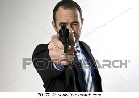 Businessman aiming a gun at camera, front view View Large Photo Image Stock Image - Businessman aiming a gun at camera, front view . Fotosearch