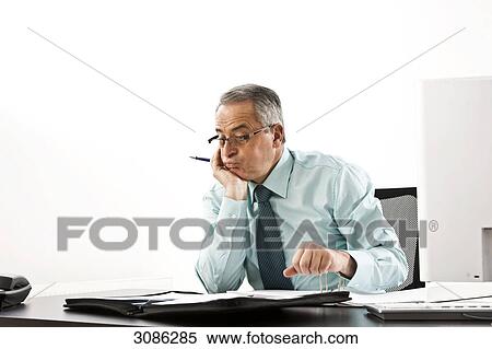 Stock Photography - Businessman sitting in front of a document case, hand on chin . Fotosearch