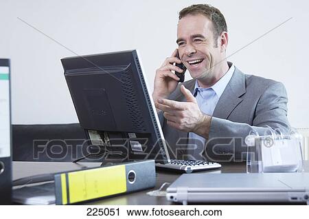Stock Image - Businessman talking on mobile phone and smiling . Fotosearch