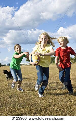 Stock Image - Children running over field, front view . Fotosearch