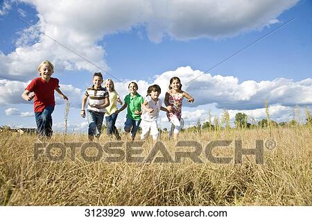 Stock Photo - Children running over field, low angle view . Fotosearch