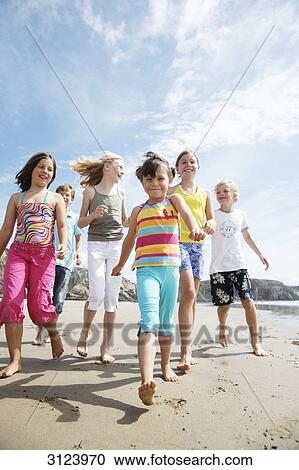 Children walking on the beach, front view, low angle view View Large Photo Image Stock Image - Children walking on the beach, front view, low angle view . Fotosearch