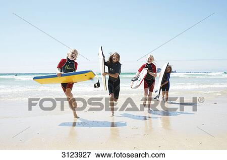 Children with surfboards running on the beach, front view View Large Photo Image Stock Photo - Children with surfboards running on the beach, front view . Fotosearch