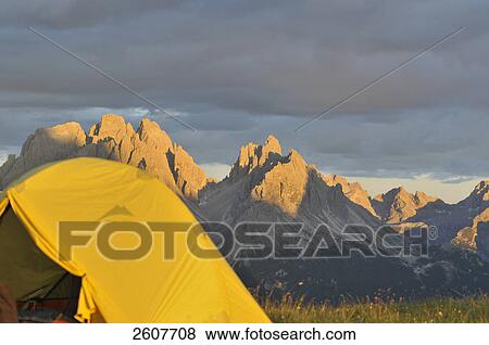 Stock Photo - Close-up of camp with mountain range in background during dusk, Italy . Fotosearch