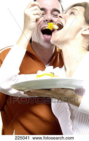Stock Image - Close-up of couple eating cake . Fotosearch