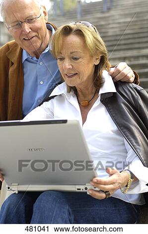 Stock Image - Close-up of couple looking at laptop . Fotosearch