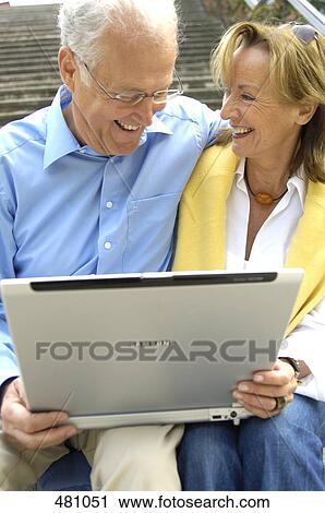 Close-up of couple using laptop and smiling View Large Photo Image Stock Image - Close-up of couple using laptop and smiling . Fotosearch
