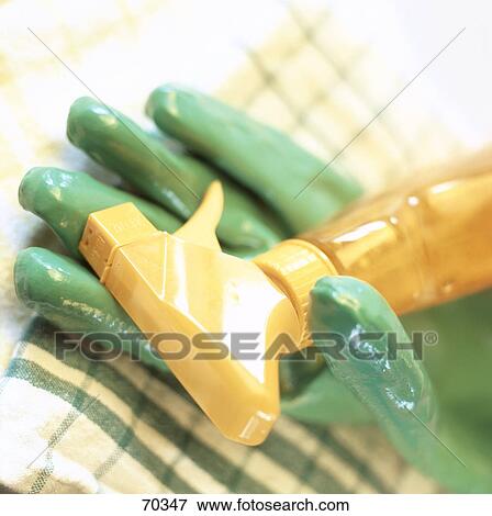 Stock Photo - Close-up of gardening glove and spray bottle . Fotosearch