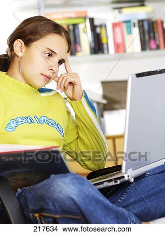 Close-up of girl looking at laptop and thinking  View Large Photo Image Picture - Close-up of girl looking at laptop and thinking . Fotosearch