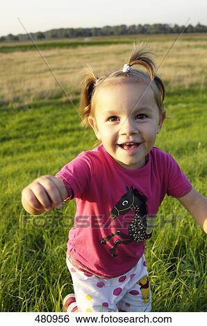 Close-up of girl running in field View Large Photo Image Stock Photograph - Close-up of girl running in field . Fotosearch