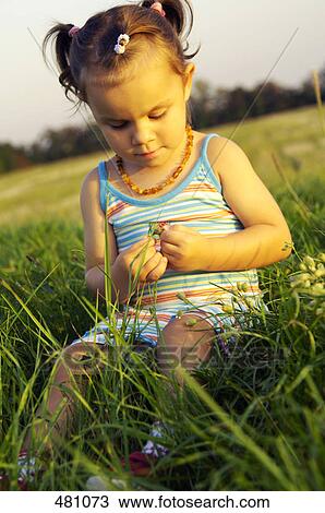 Close-up of girl sitting in field View Large Photo Image Stock Image - Close-up of girl sitting in field . Fotosearch