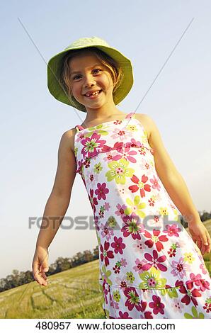 Close-up of girl smiling in field View Large Photo Image Stock Photo - Close-up of girl smiling in field . Fotosearch