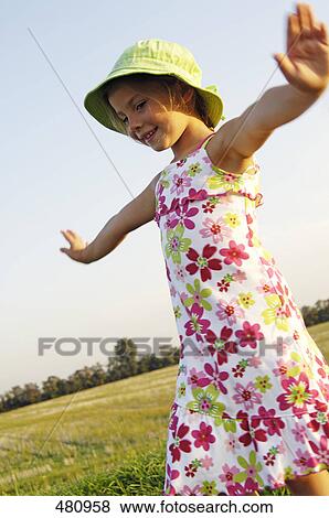 Close-up of girl spreading her arms in field View Large Photo Image Stock Photo - Close-up of girl spreading her arms in field . Fotosearch