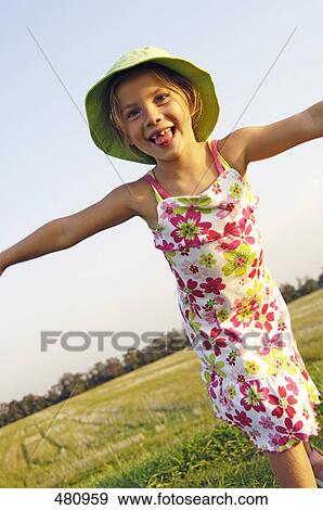 Close-up of girl spreading her arms in field View Large Photo Image Stock Photo - Close-up of girl spreading her arms in field . Fotosearch