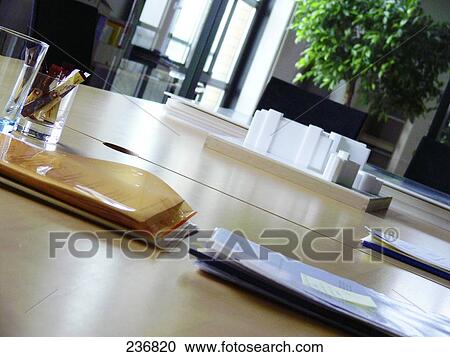 Stock Image - Close-up of glass of water and files on table . Fotosearch