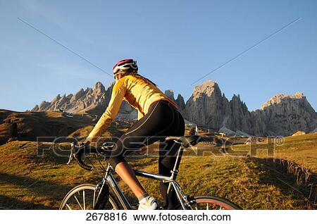 Stock Photograph - Close-up of mountain biker in front of mountains, Dolomites, Italy . Fotosearch