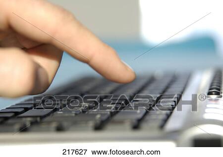 Stock Photo - Close-up of person's finger using computer keyboard . Fotosearch
