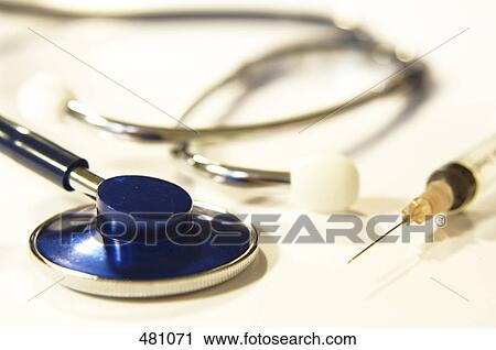 Stock Image - Close-up of stethoscope and syringe . Fotosearch