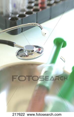 Stock Image - Close-up of stethoscope and syringes . Fotosearch
